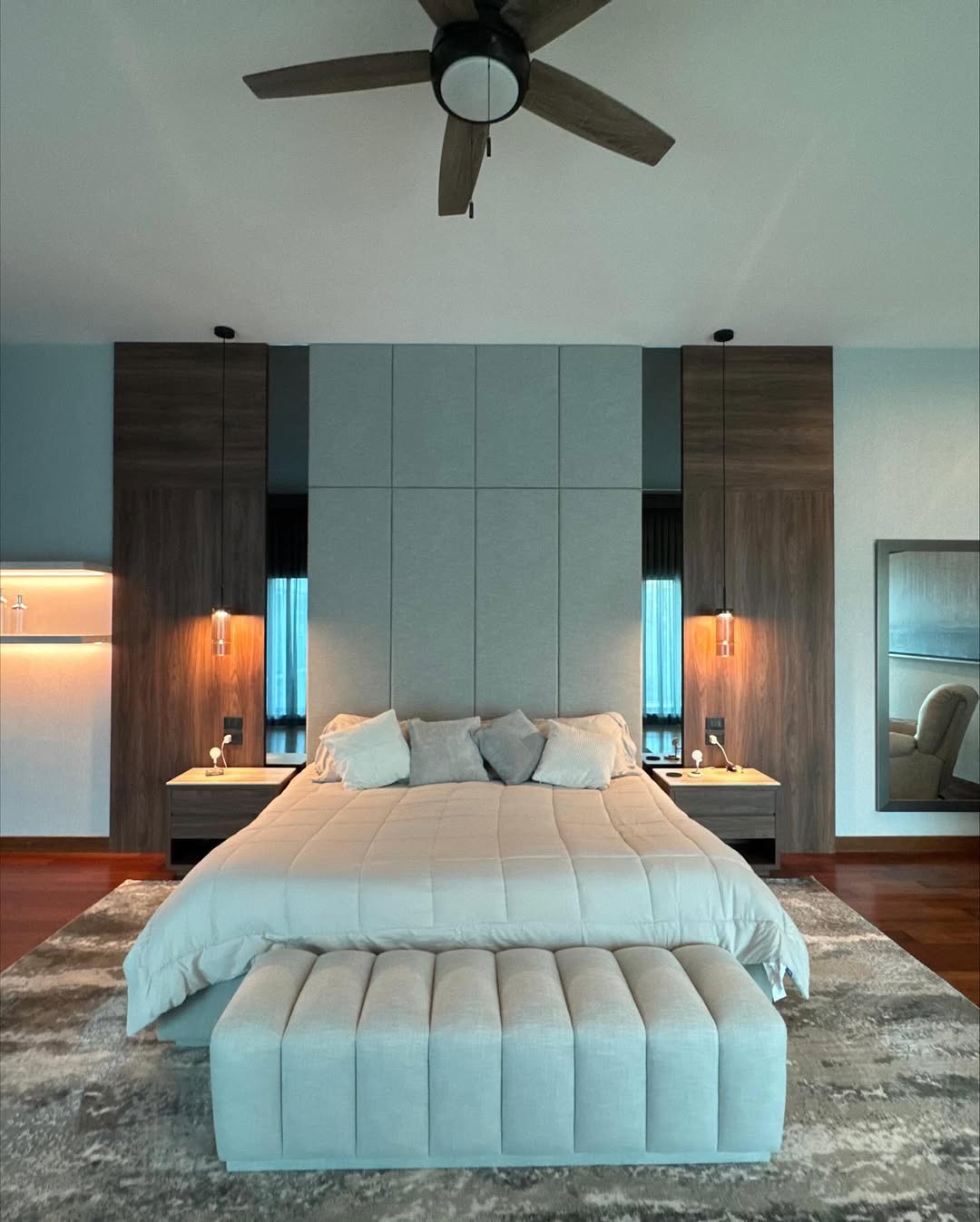 Master suite with custom walnut wardrobes flanking upholstered headboard wall